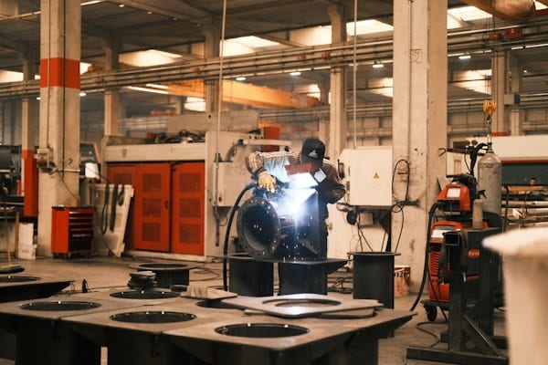 仮画像：工場で配管のフランジ部を溶接する作業者